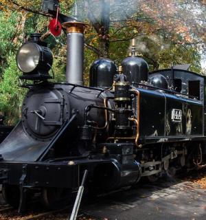 an old steam engine train on display in a park