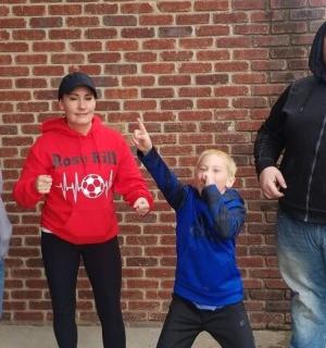 skupina lidí stojících před cihlovou zdí