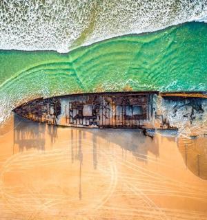 an aerial view of a wave on a beach