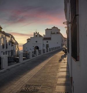 一条小巷里有白色的建筑,背景是日落