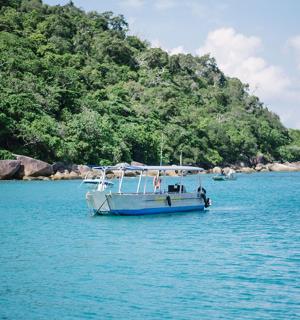 一艘船漂浮在山边的水面上