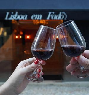 two people holding up glasses of red wine