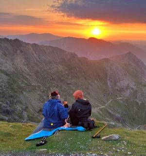 两个人坐在山顶上看日落