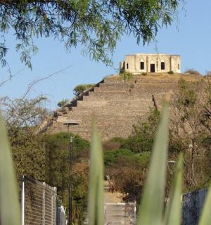 an old building on top of a hill with stairs