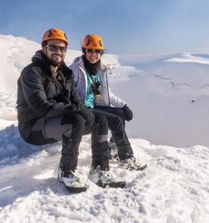 一男一女坐在白雪皑皑的山顶上