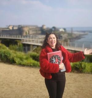 žena v červeném svetru držící knihu