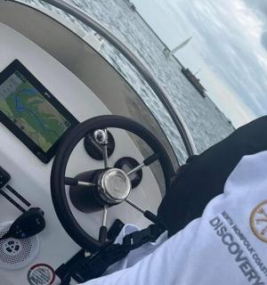 a steering wheel of a boat with a compass