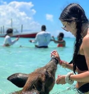 a woman playing with a dog in the water