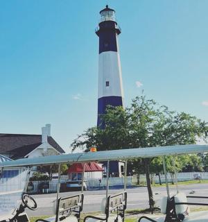 a lighthouse with benches in front of a building