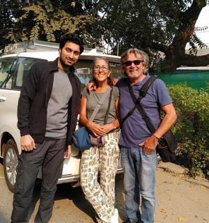 dva muži a žena stojící před autem