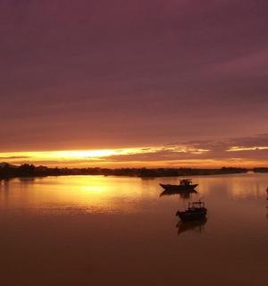 河上的日落,水中有船