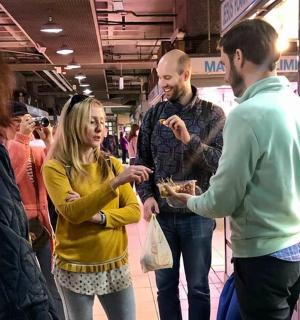 a group of people standing in a store eating food