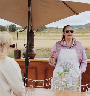 eine Frau in einer Schürze steht unter einem Regenschirm
