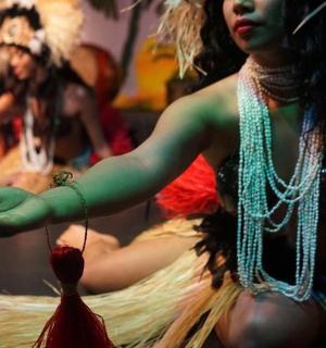 一位身着戏服的女士拿着草裙舞