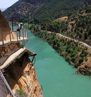 a man standing on the edge of a bridge over a river