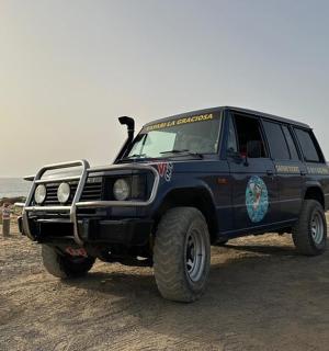 一辆蓝色吉普车停在沙滩上