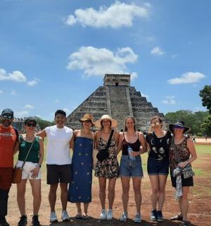 a group of people standing in front of a pyramid