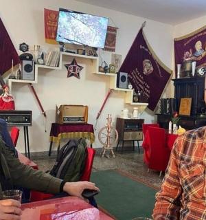 du vyrai sėdi prie stalo kambaryje