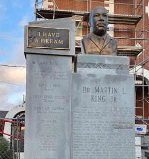 一名男子坐在标志牌上的雕像