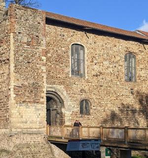 a person standing in front of a large brick building
