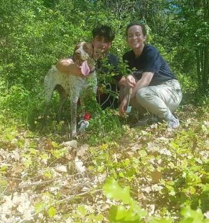 两个人和一只狗跪在草地上