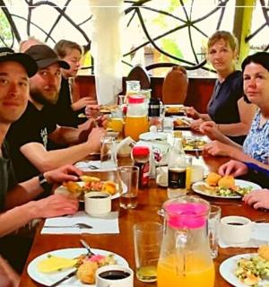 a group of people sitting at a table eating food