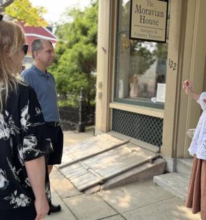 dvě ženy a muž stojící před budovou