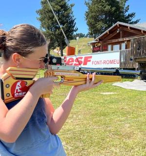 一个女孩拿着玩具枪站在房子前面