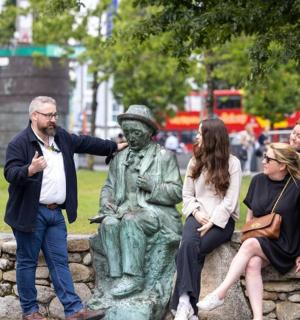 a group of people standing around a statue in a park