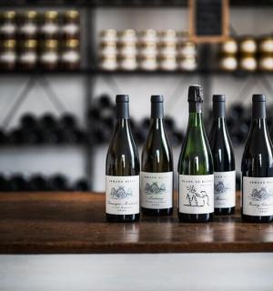 skupina čtyř lahví vína stojících na pultu