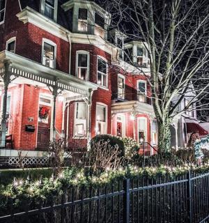 a large red brick house with christmas lights on it