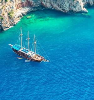 一艘船漂浮在悬崖附近的水中