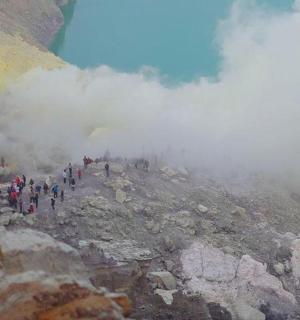 a group of people walking on a mountain in the clouds