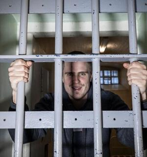 en mand kigger gennem tremmerne i et bur