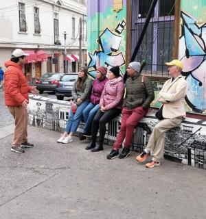 eine Gruppe von Menschen, die auf einer Bank auf einer Straße sitzen
