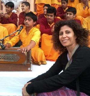 žena sedící před skupinou mnichů