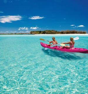 两名女子在海上划着粉色皮划艇