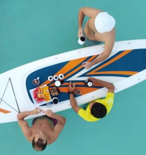 zwei Personen stehen neben einem Surfbrett