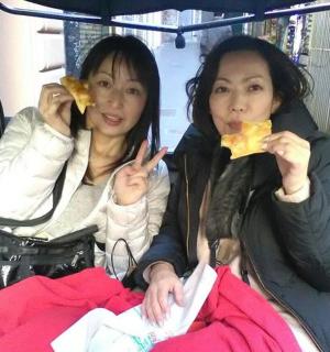 两个女人坐在公交车上吃东西