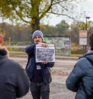 a man holding up a sign in a park