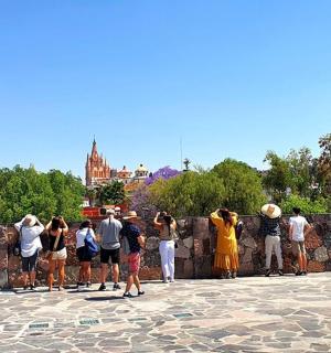 a group of people looking over a stone wall