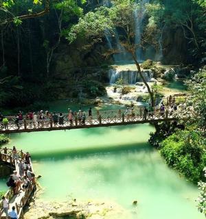 a group of people crossing a bridge over a river
