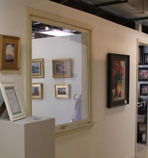 muzejní exponát se zarámovaným obrazem na zdi