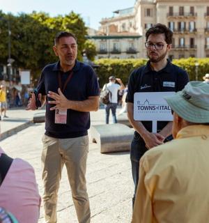 muž držící transparent před skupinou lidí