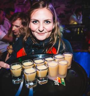 isang babae na may hawak na tray ng labindalawang baso ng beer