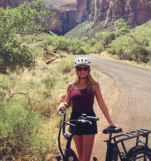 žena stojící vedle kola na silnici