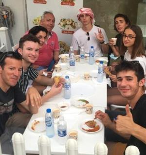 a group of people sitting around a table eating food