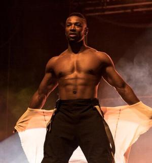 一名男子赤裸上身走在舞台上