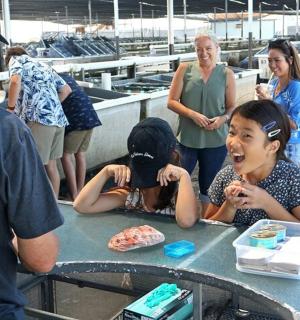 skupina lidí stojících kolem stolu s mužem