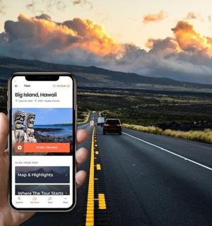 a person holding a cell phone in front of a road